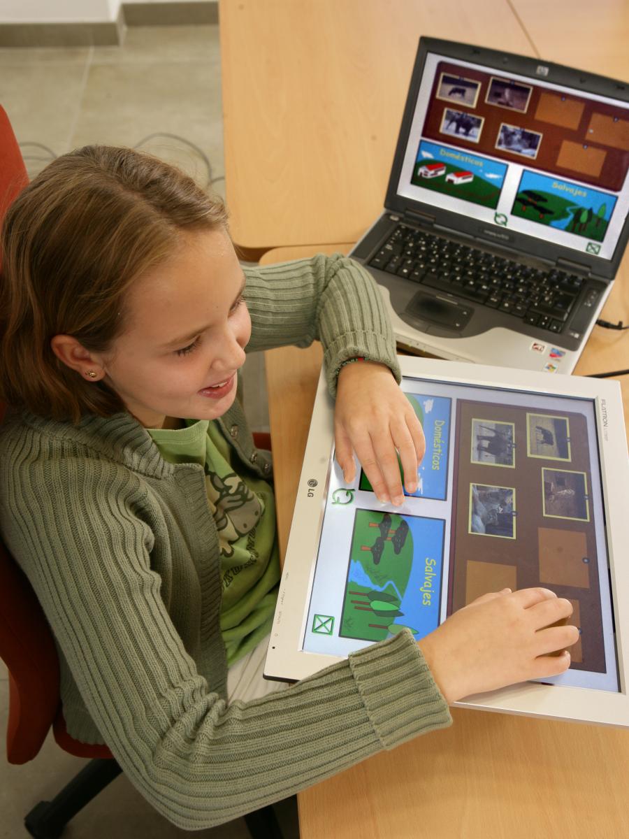Una niña ciega utilizando una pizarra digital conectada a un ordenador