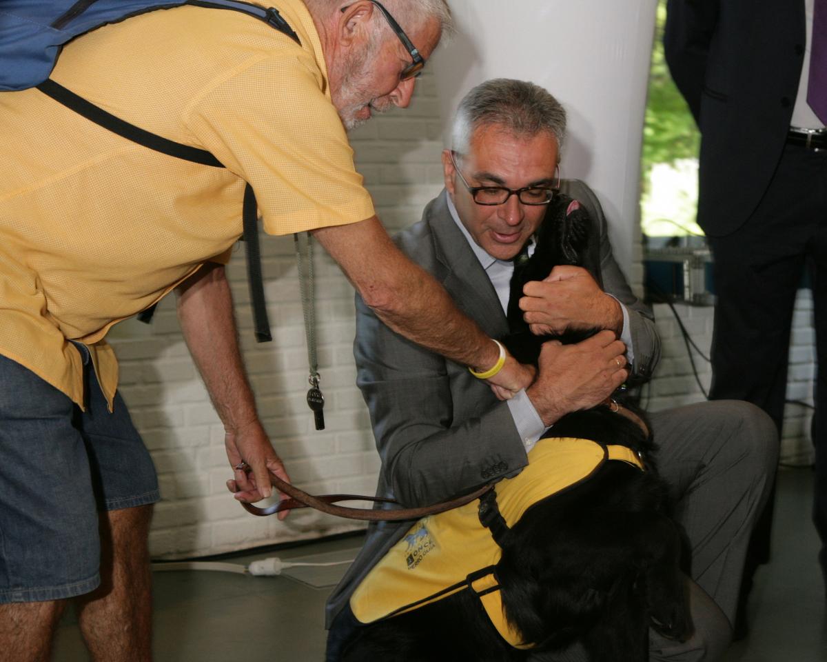 El consejero Carlos Izquierdo abraza a uno de los perros en formación