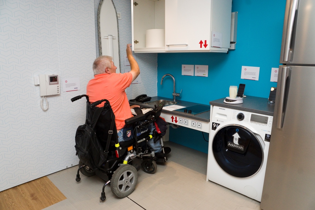 Un usuario en silla de ruedas accede a la cocina accesible dentro de la casa