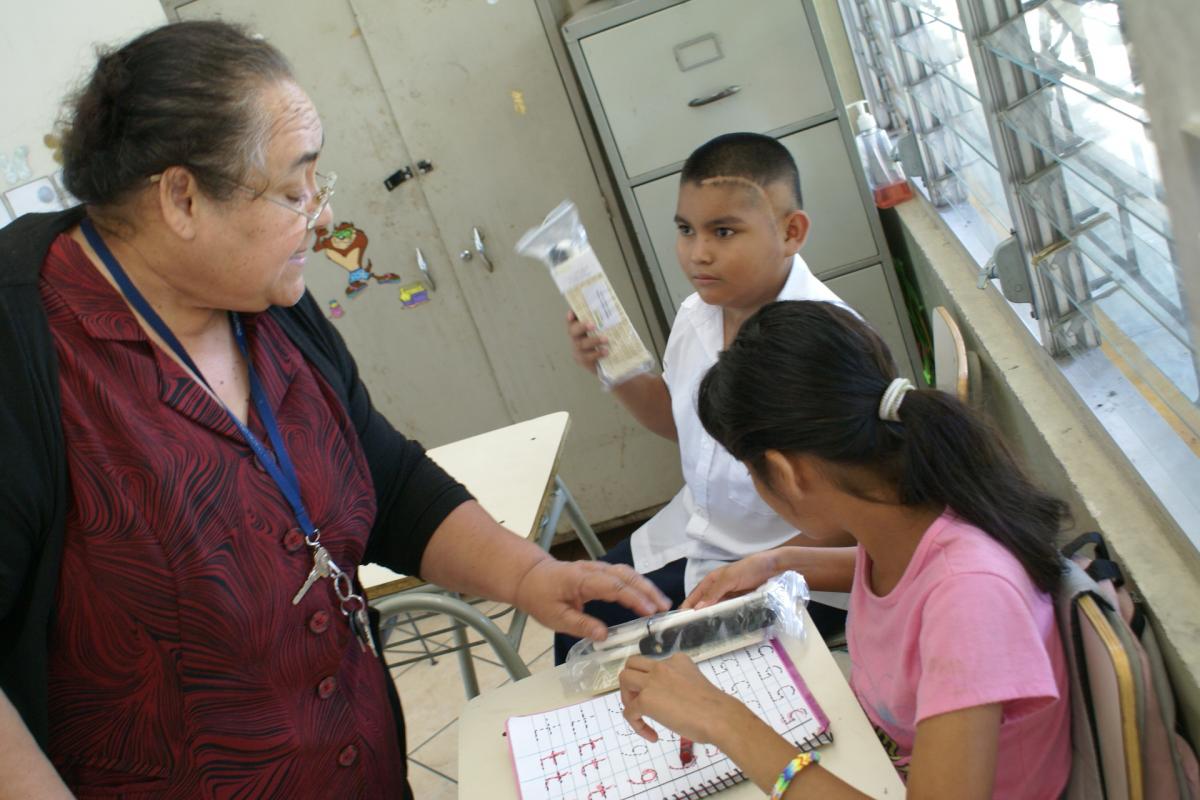 Una maestra entrega el material nuevo en El Salvador 