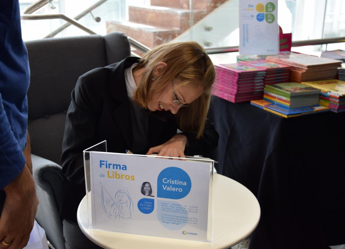 Cristina Valero firmando libros en el estand de ILUNION Retail