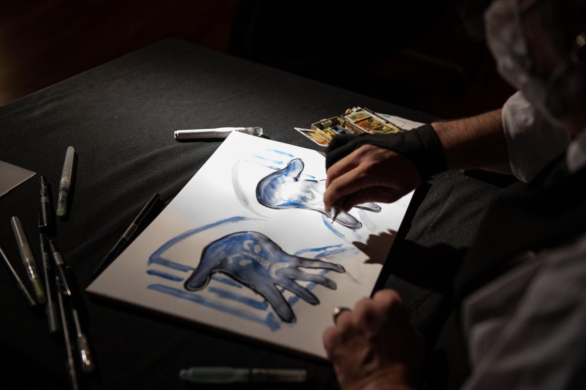El dibujante recrea el logo de las manos