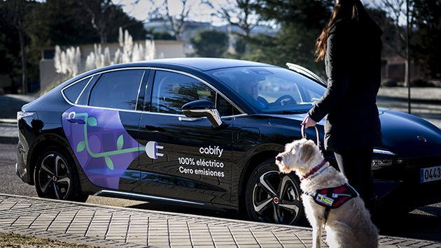 Usuaria de perro guía delante de un vehículo de Cabify