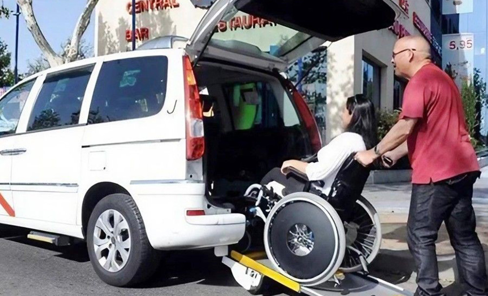 Persona en silla de ruedas subiendo a un taxi adaptado