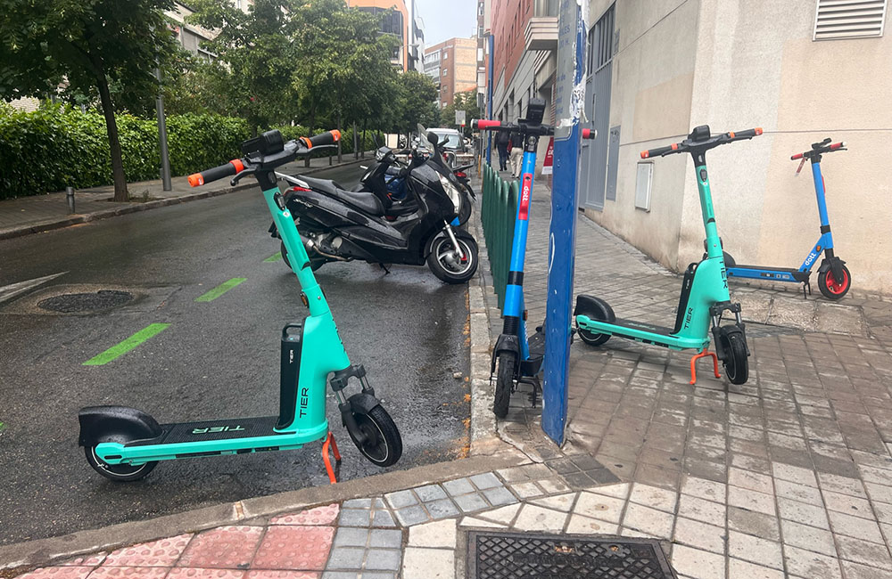 Primer plano de varios patinetes mal ubicados en la calle