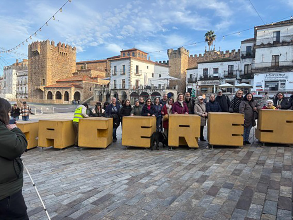 Foto de familia delante de las letras de Cáceres