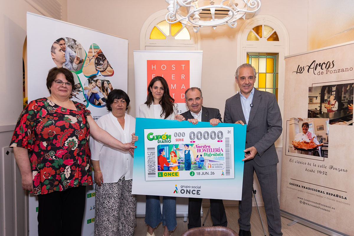 Los participantes en la presentación posan con la imagen del cupón