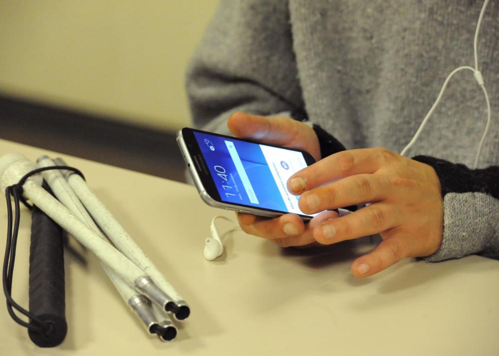 Una persona ciega aprendiendo el uso del teléfono móvil