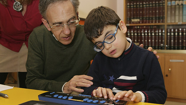 alumno_ciego_aprende_junto_a_su_profesor_el_uso_de_la_linea_braille.jpg