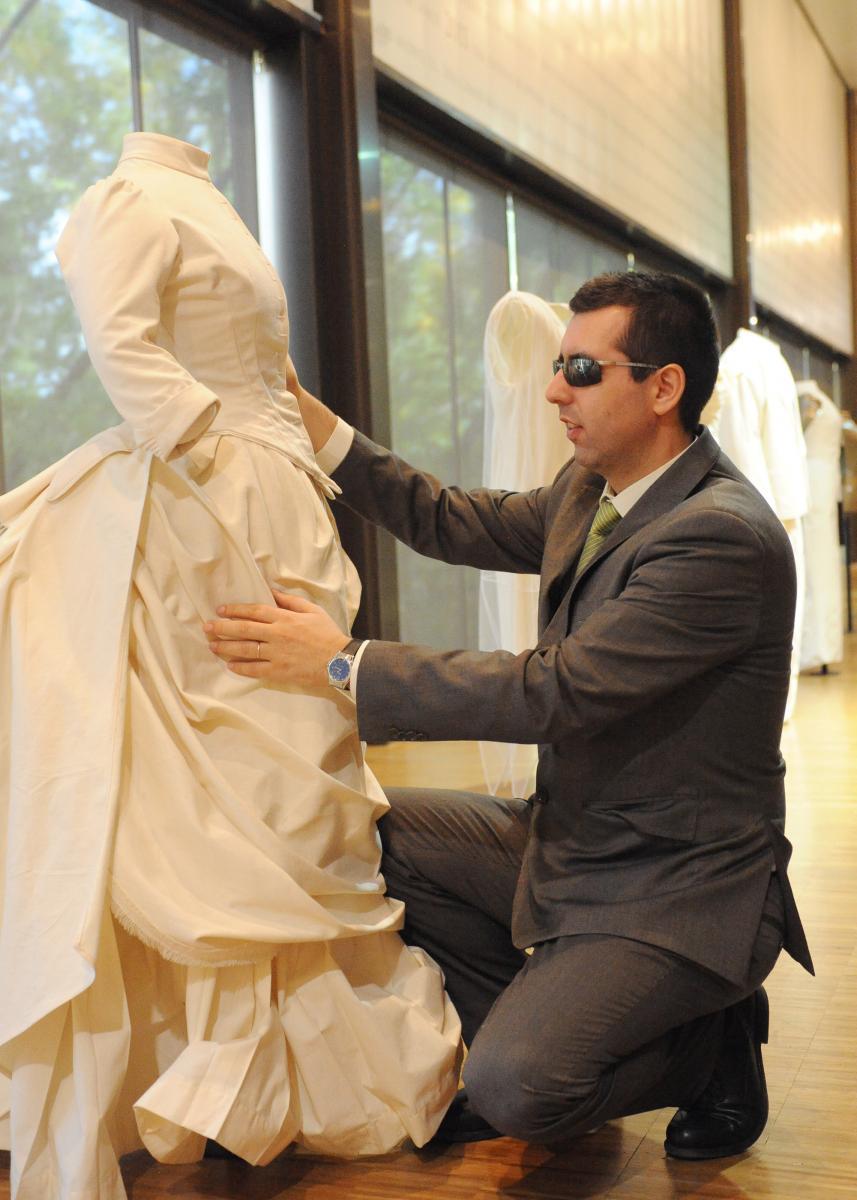 Un afiliado tocando uno de los trajes expuestos en el Museo del Traje