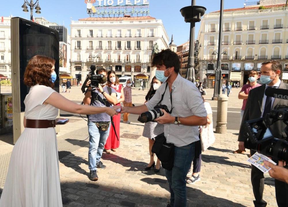 Díaz Ayuso repartiendo cupones entre los periodistas