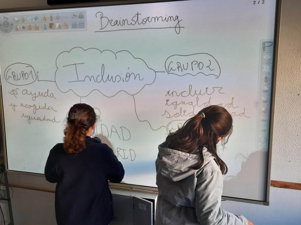 Dos alumnos trabajan sobre una pizarra