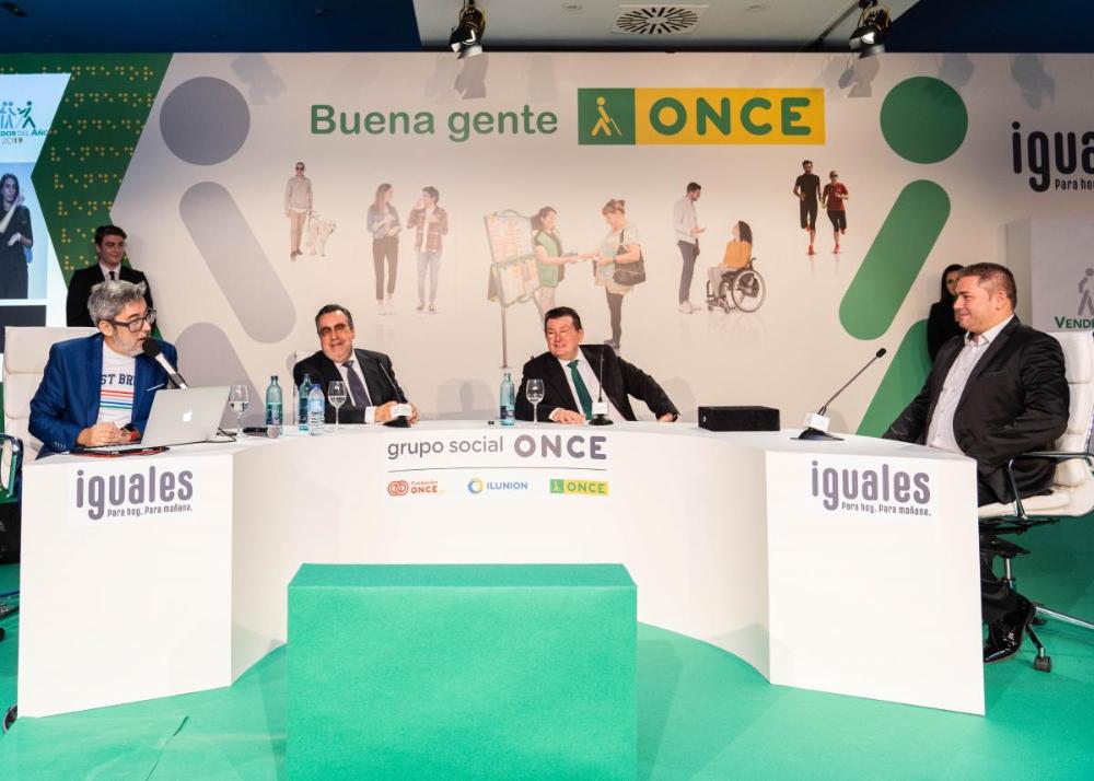Manuel en la mesa junto al conductor del acto y los responsables de ONCE