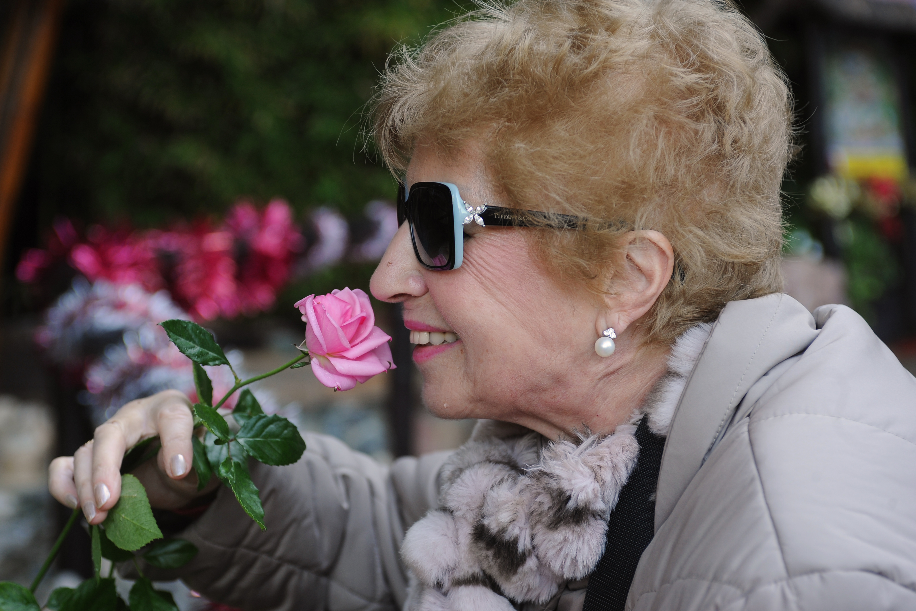 mujer_mayor_afiliada_oliendo_una_flor.jpg