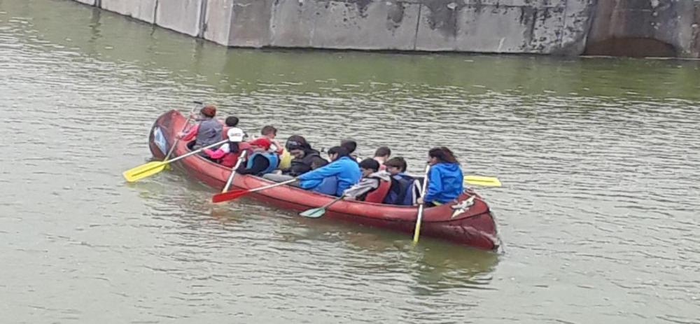 Un grupo de chavales en un kayak junto a los monitores