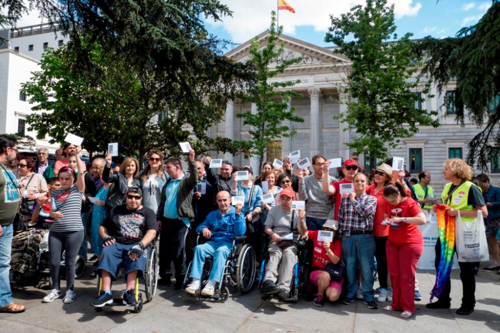 Un amplio grupo de personas con y sin discapacidad posan delante del Congreso durante la concentración