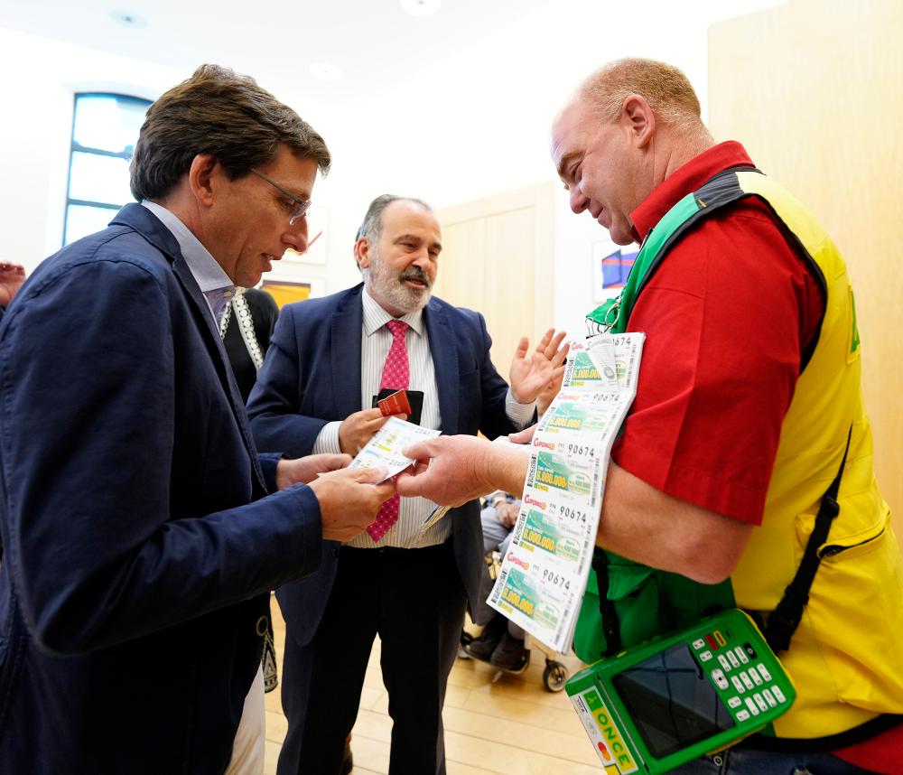 El alcalde de Madrid junto a Luis Natalio Royo comprando cupones