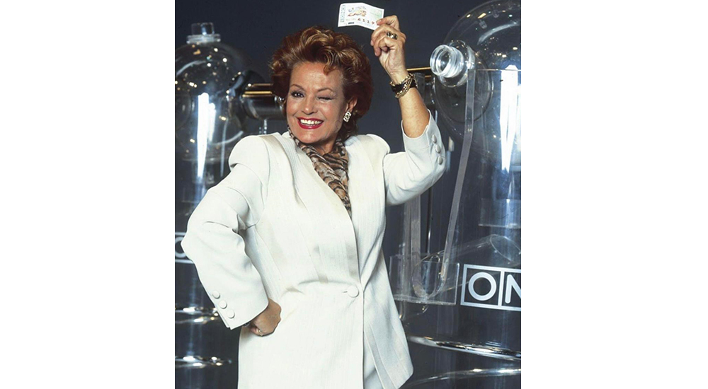 Carmen Sevilla delante de los bombos y con un cupón en la mano