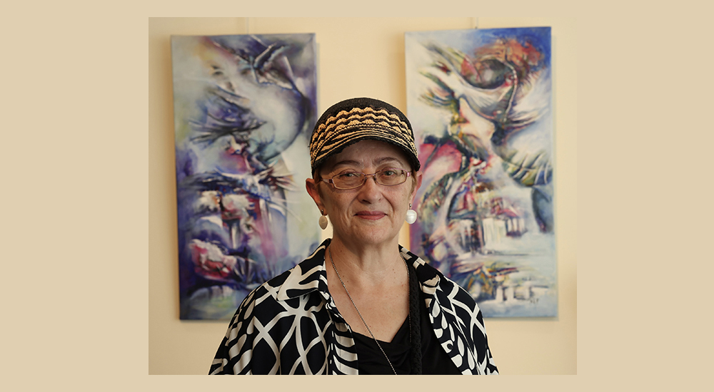 Mª Ángeles Lozano junto a dos de sus pinturas