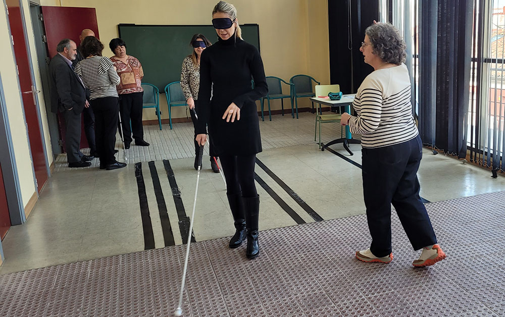 Mar Espinar en la aula de movilidad con un antifaz y el bastón blanco