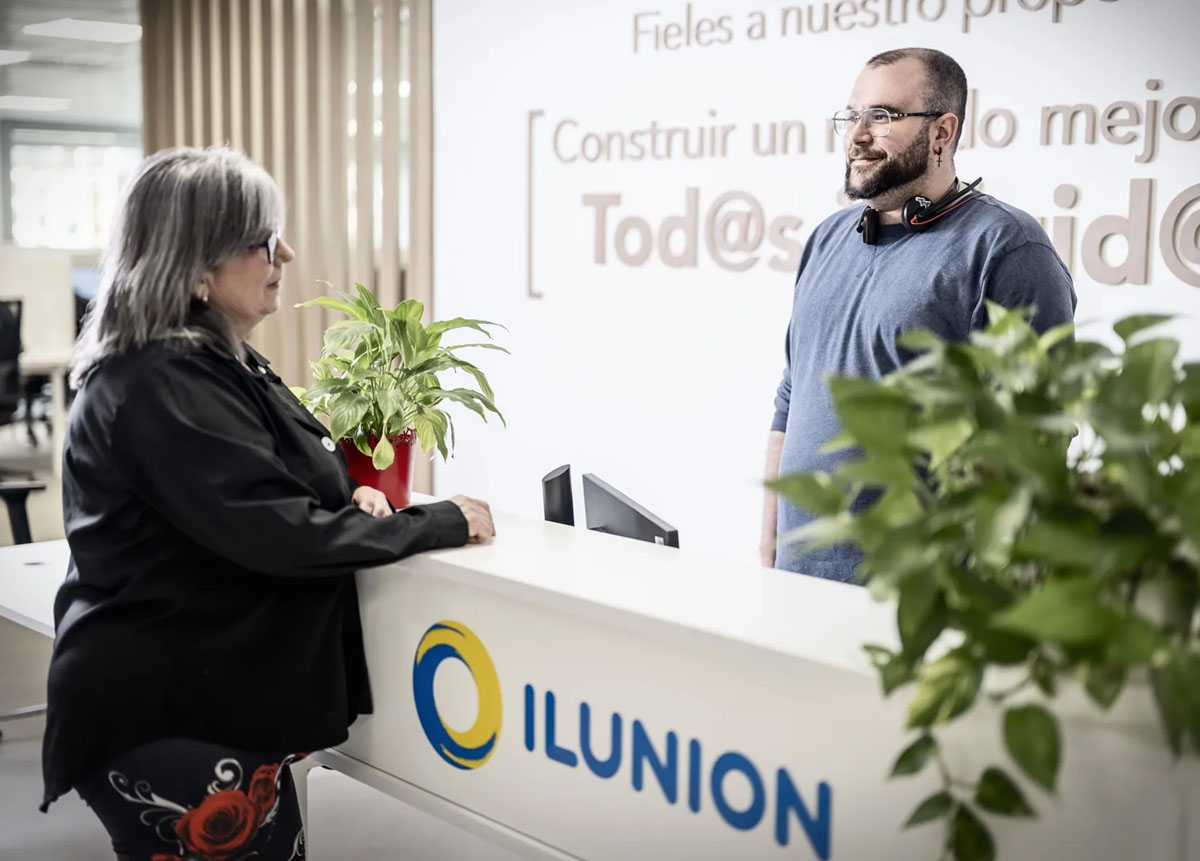 Un trabajador de Ilunion atendiendo a una clienta